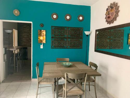 a dining room with a wooden table and blue walls at Casa Madero Beautiful 2BR apt one Block from Malecón! Best Location! in La Paz