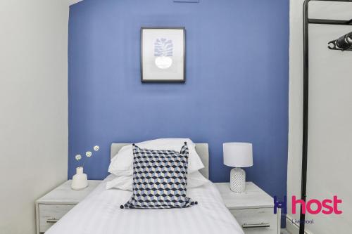 a blue bedroom with a bed and a blue wall at Host Liverpool - Chic family spot, near Anfield & centre in Liverpool
