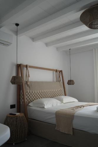 a bedroom with a bed and two pendant lights at Azul Houses Kythnos in Kithnos