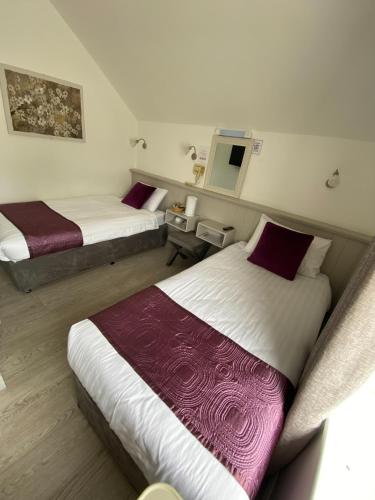 a hotel room with two beds and a tv at The Town House Hotel in Naas