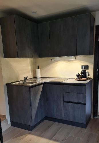 a kitchen with black cabinets and a sink at Cocooning in Arvier
