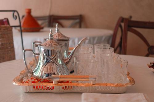斯庫拉的住宿－coooperative_ogandou_skoura，茶壶托盘上茶壶,桌子上放着玻璃杯