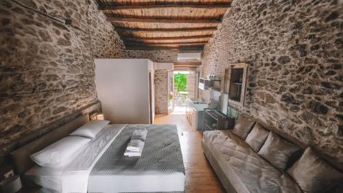 a bedroom with a bed and a stone wall at The Cellar Studios - by Avelink in Spáta
