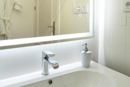 a bathroom with a white sink with a mirror at Casa Rural La Posada del 42 in Carrascalejo