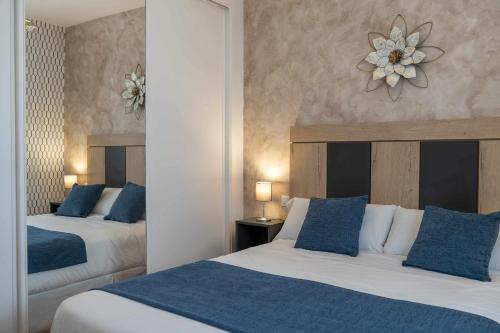 Habitación de hotel con 2 camas y almohadas azules en Casa Rural La Posada del 42, en Carrascalejo