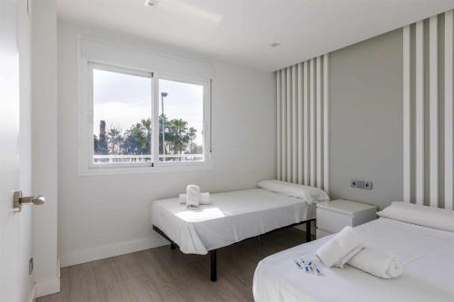 sala szpitalna z dwoma łóżkami i oknem w obiekcie A&N Seafront Torre del Mar w mieście Torre del Mar