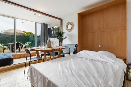 une chambre avec un lit et une table avec des chaises dans l'établissement Cabana & Cap'Studio, au Cap d'Agde