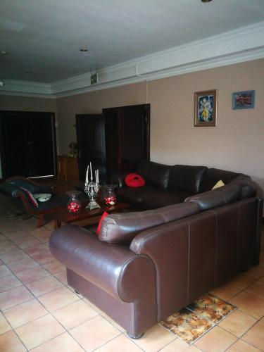 a living room with a brown leather couch and a table at Condor House in Centurion