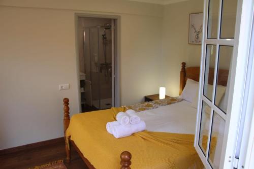 a bedroom with a bed with two towels on it at Casa da Tia Clementina in Santana
