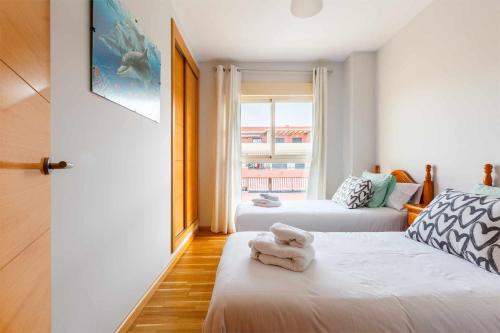 een kleine kamer met twee bedden en een raam bij A&N La Vega 13 in Torre del Mar