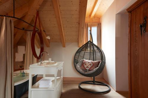 a room with a hanging chair and a sink at Hotel De Londres in Brig