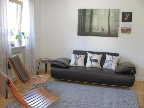 a living room with a black couch and chairs at #7 Ferienhaus mit Schlossblick Trunkelsberg für max 6 Personen,Küche komplett eingerichtet, 2 Bäder 3 Schlafzimmer Top-Ausstattung in Trunkelsberg