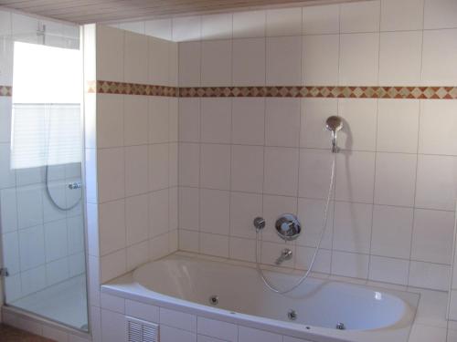 a bath tub with a shower in a bathroom at #7 Ferienhaus mit Schlossblick Trunkelsberg für max 6 Personen,Küche komplett eingerichtet, 2 Bäder 3 Schlafzimmer Top-Ausstattung in Trunkelsberg