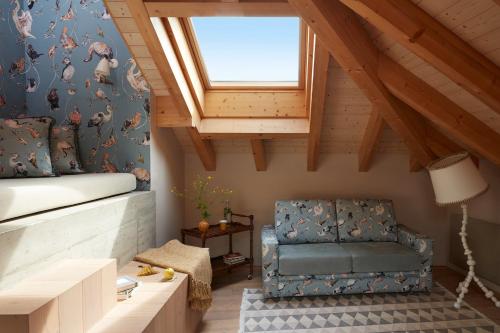 Zimmer im Dachgeschoss mit einem Stuhl und einem Fenster in der Unterkunft Hotel De Londres in Brig