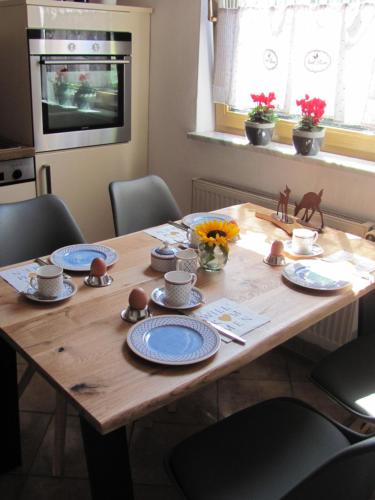 a wooden table with blue and white plates on it at #7 Ferienhaus mit Schlossblick Trunkelsberg für max 6 Personen,Küche komplett eingerichtet, 2 Bäder 3 Schlafzimmer Top-Ausstattung in Trunkelsberg