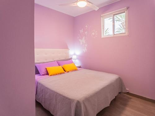 Dormitorio púrpura con cama con almohadas amarillas y moradas en MARIPOSA en Frontera/Primavera, en Costa del Silencio
