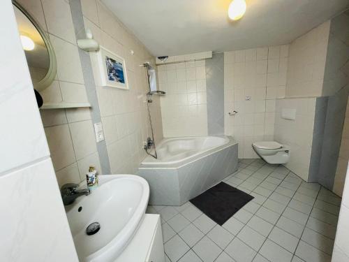 a bathroom with a tub and a sink and a toilet at Edu Home Bremen in Bremen
