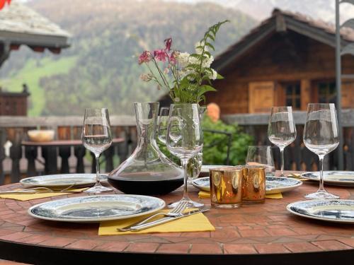 a table with wine glasses and a vase of flowers at Chalet Rayon de Soleil in Gryon