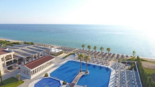 an aerial view of a resort with a swimming pool and the ocean at Potidea Palace Hotel in Nea Potidaea