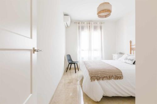 1 dormitorio blanco con 1 cama y 1 silla en A&N Algarrobo Beach, en Algarrobo