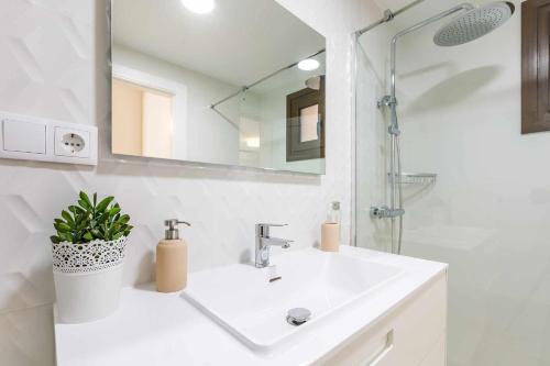 ein weißes Badezimmer mit einem Waschbecken und einem Spiegel in der Unterkunft A&N Algarrobo Beach in Algarrobo