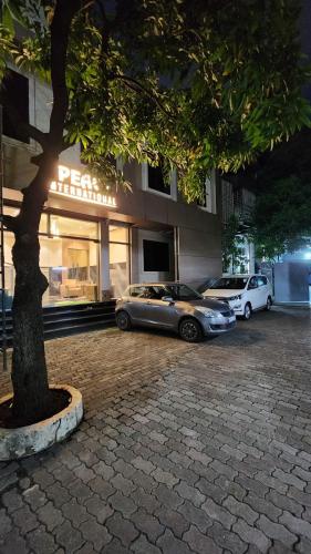 two cars parked in a parking lot in front of a building at Peace International in Mumbai