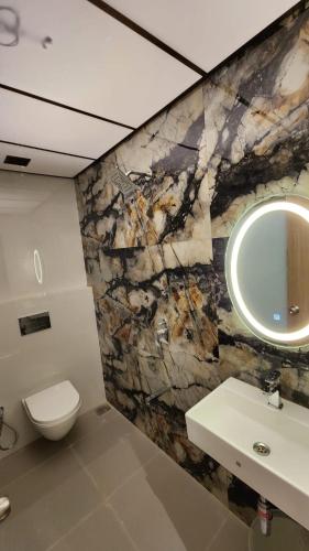 La salle de bains est pourvue de toilettes, d'un lavabo et d'un miroir. dans l'établissement Peace International, à Mumbai