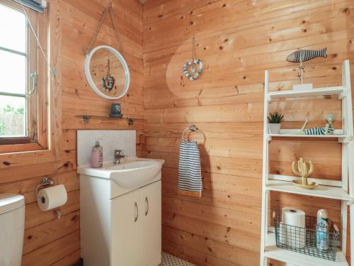 a bathroom with wooden walls and a sink at Pigsfoot Lodge in Tiverton
