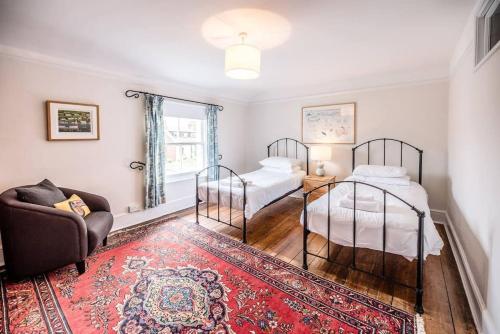1 Schlafzimmer mit 2 Betten, einem Stuhl und einem Teppich in der Unterkunft The Old Rope House in Southwold
