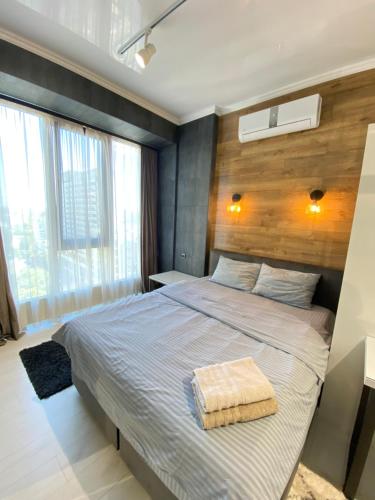 - une chambre avec un grand lit et un mur en bois dans l'établissement Ultracentral Lux Apartment, à Chişinău
