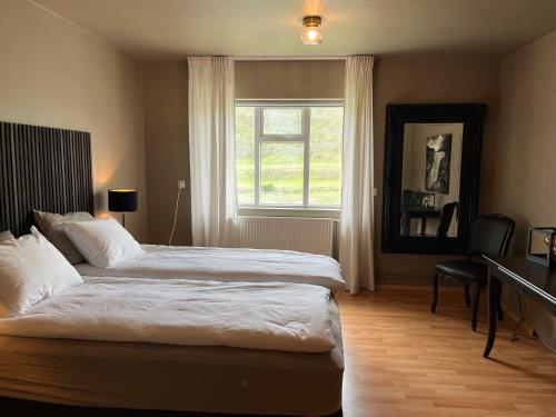 Un dormitorio con una cama grande y una ventana en Jökla Guesthouse, en Skjöldólfsstaðir