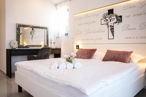 a bedroom with a white bed with a cross on the wall at Villa Istra Relax Smaragd in Rebići