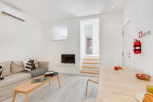 a white living room with a couch and a table at Alcantara Charm 3BR Apartments in Lisbon
