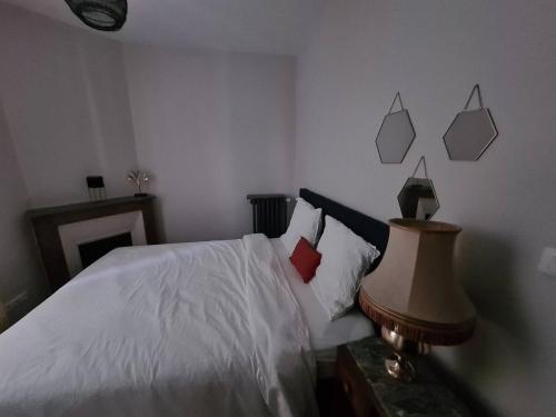 - une chambre avec un lit doté de draps blancs et d'oreillers rouges dans l'établissement MAISON AMPERE, à Limoges