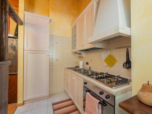 a kitchen with white cabinets and a stove top oven at Dosso Aprica Apartment in Aprica