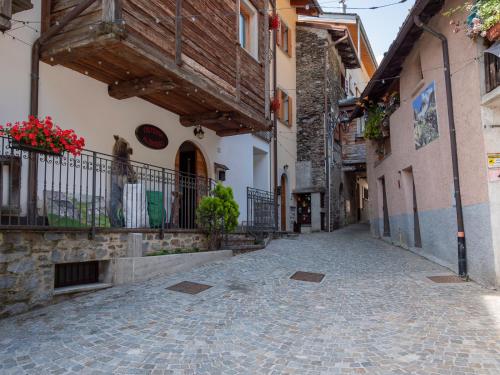 an alley in a town with buildings and flowers at Dosso Aprica Apartment in Aprica