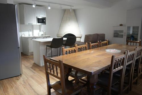 comedor y cocina con mesa de madera y sillas en Casa Margarita en Peñaranda de Duero