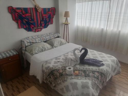 Un dormitorio con una cama con un cisne. en Apartamento sombras del titicaca, en Puno