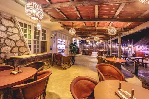 a restaurant with tables and chairs and a bar at Hotel CasaBakal - A pie de Laguna - Bacalar in Bacalar