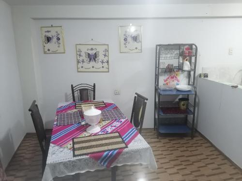 een eettafel met een tafelkleed en een plank bij Apartamento sombras del titicaca in Puno