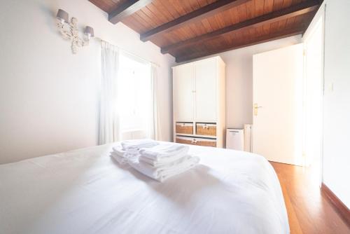 a bedroom with a white bed with towels on it at Casa Playa Graña "Ferrol" in Ferrol