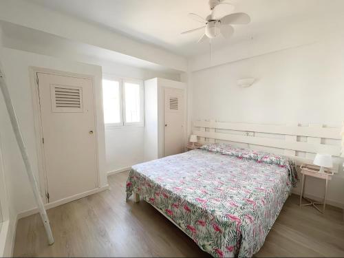 1 dormitorio blanco con 1 cama y ventilador de techo en Apartamentos Formentera Copacabana 18, en Es Pujols