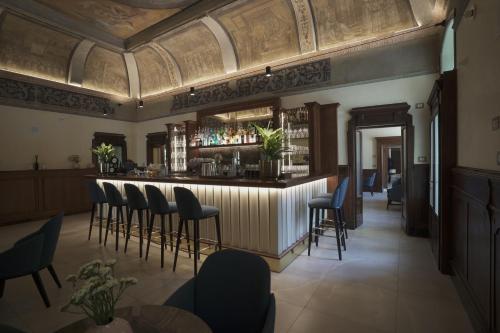 a bar in a restaurant with chairs and tables at Palazzo Santo Spirito in Bergamo