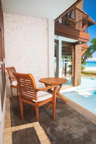 a patio with two chairs and a wooden table at Le Saint Alexis **** Hotel & Spa in Saint-Gilles les Bains