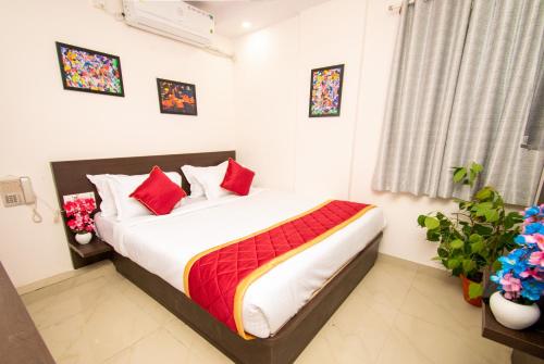 1 dormitorio con 1 cama con almohadas rojas en Octave Hotel JM Residency, en Bangalore