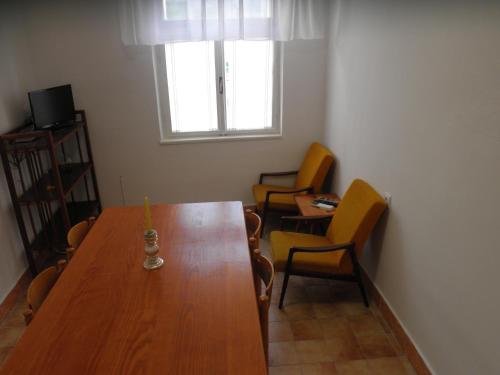 a room with a wooden table with chairs and a window at Apartment Aleta in Tisno