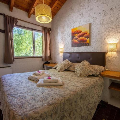 a bedroom with a bed with towels on it at Cabaña en Alta Montaña - Complejo Cabañas del Pastizal - USPALLATA, MENDOZA in Uspallata