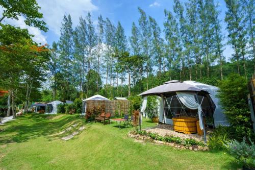 een achtertuin met een prieel en een tuin bij ไวน์แคมป์ WineCamp โดมติดลำธาร in Ban Cha-om