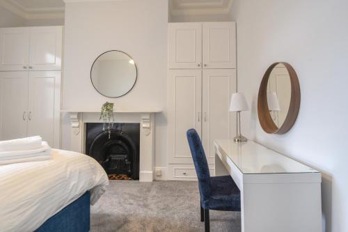 a bedroom with a bed and a desk and a mirror at Flat 2, 10 Seafield Road in Seaton