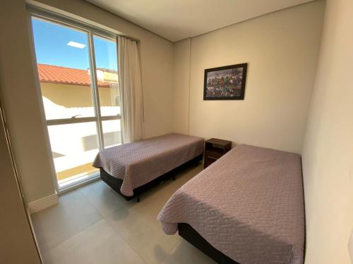 1 dormitorio con 2 camas y ventana grande en Apartamento amplo bem equipado, en João Neiva